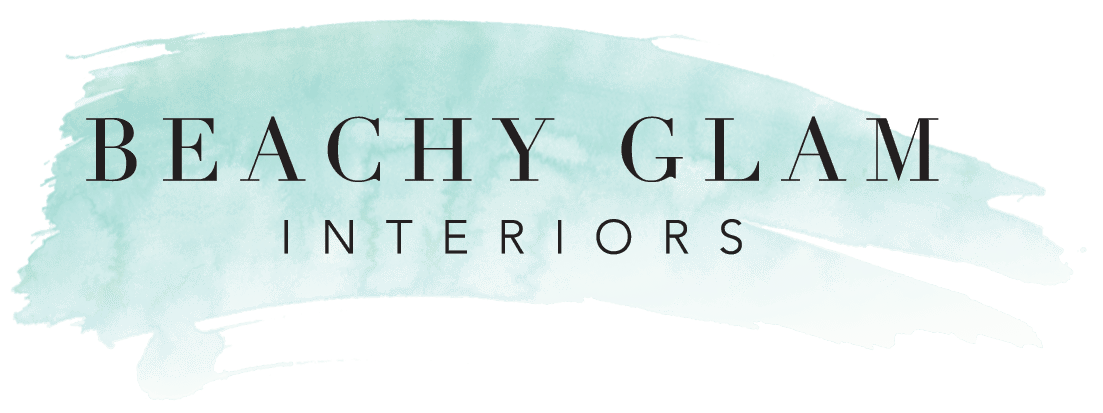 A watercolor brushstroke background with the text "BEACHY GLAM INTERIORS" centered in bold and elegant black font.